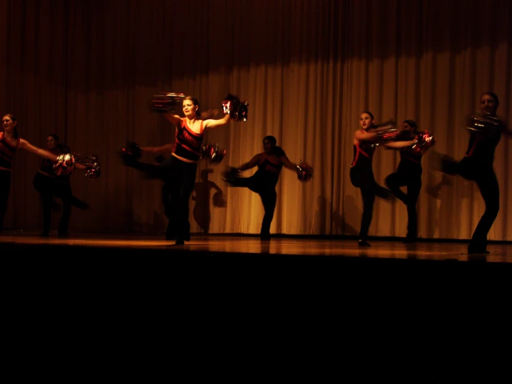 dancers on stage with red lights in background