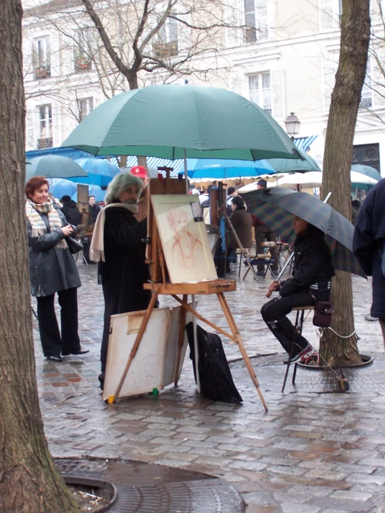 a woman with an umbrella is painting outside