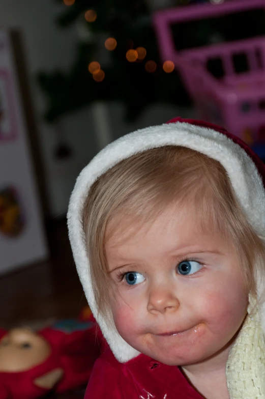 a little girl is wearing a red and white coat