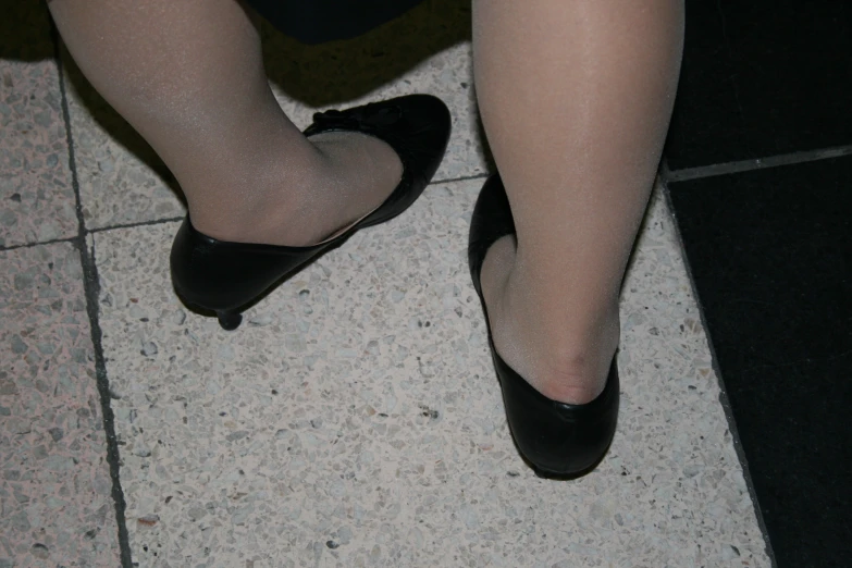 the feet and ankles of a woman wearing high heels