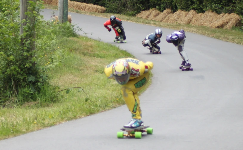 skateboarders competing in a race on an asphalt road