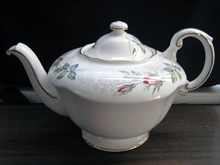 the white teapot is set on top of a table