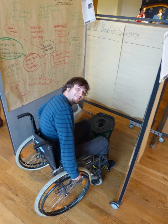 a man with a wheelchair in front of a board