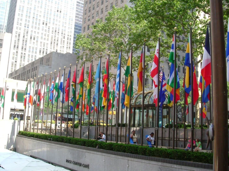 people are walking along the wall of a building and flags