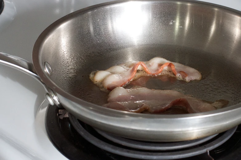 meat and other ingredients are being stirred in a wok on a stove