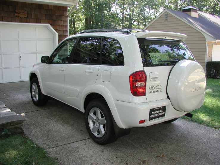 a white vehicle is parked in front of a home