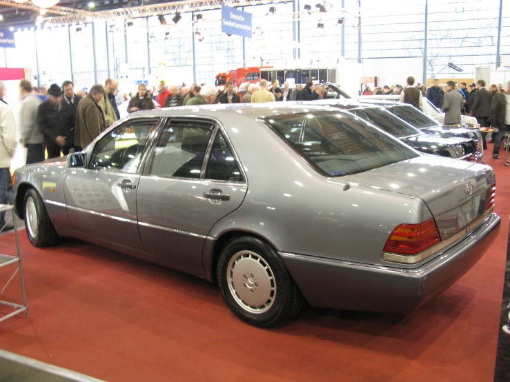 people looking at cars on display at a car show