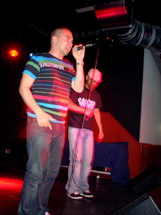 two men are singing into microphones at a concert