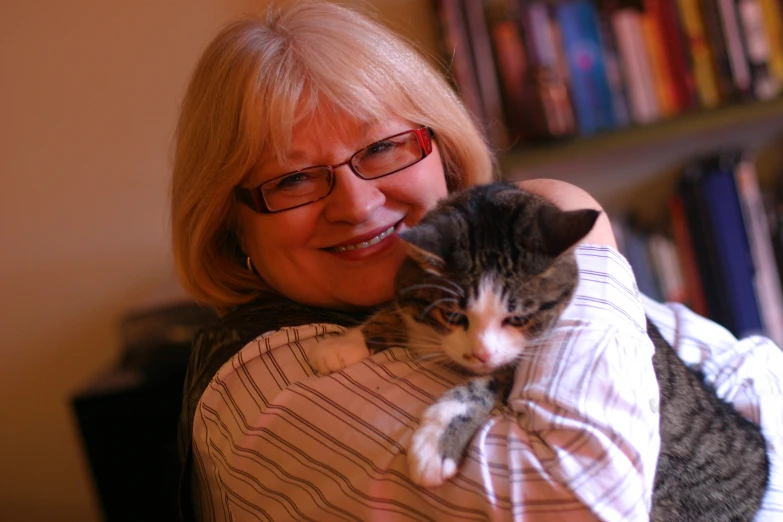 a lady that is holding a cat up