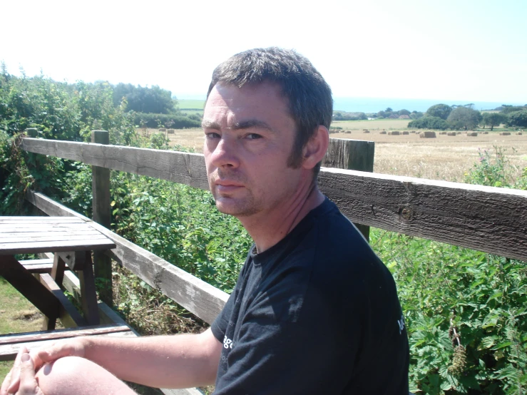 a man standing near a bench looking back at the camera