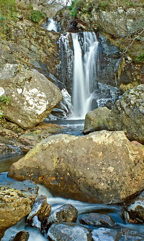 small waterfall that is close to some rocks