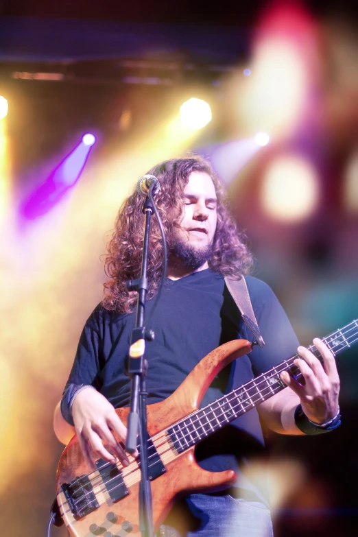 a man in black shirt playing guitar on stage