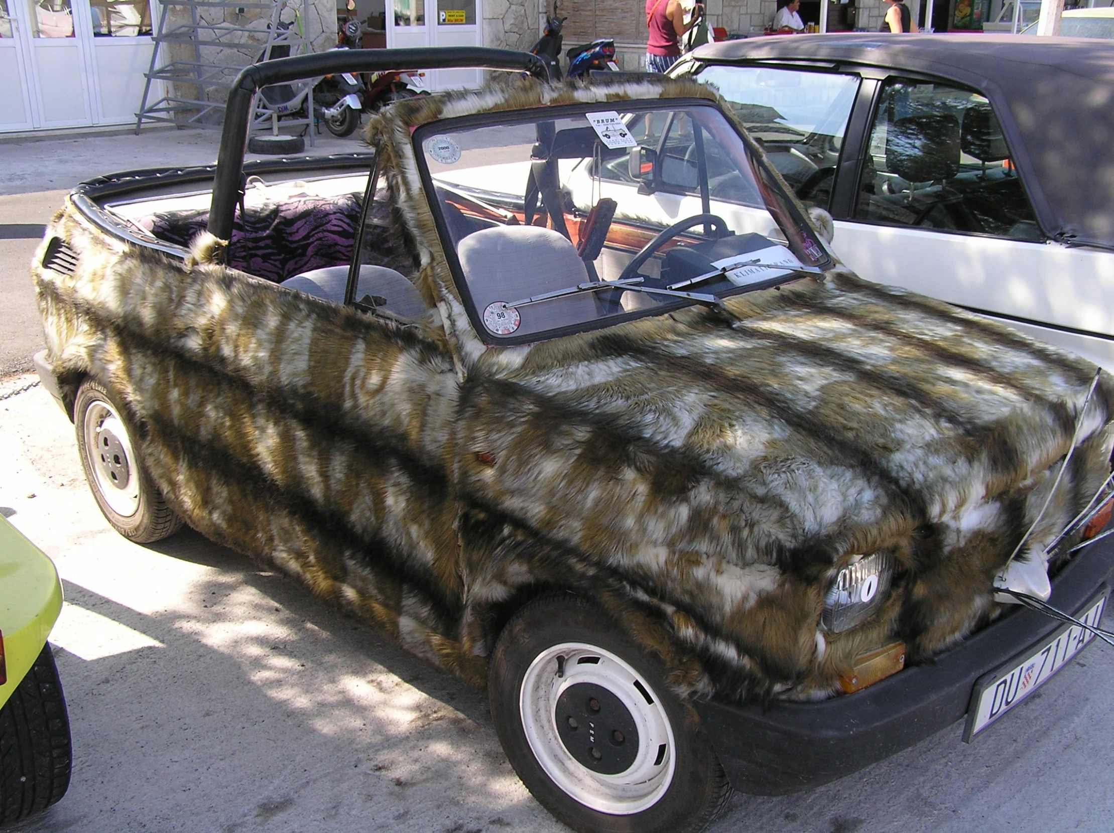 an old model car with soing on top and some cars behind it