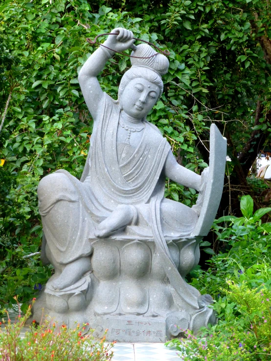 a statue of a seated buddhist monk outside