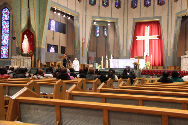 large crowd of people sitting in pews to hear a funeral