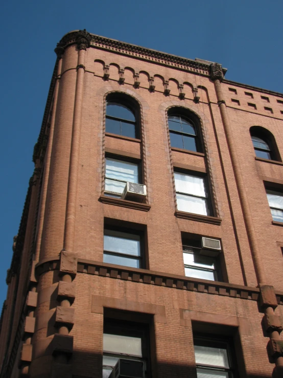 an exterior view of a brick building with decoratively designed windows