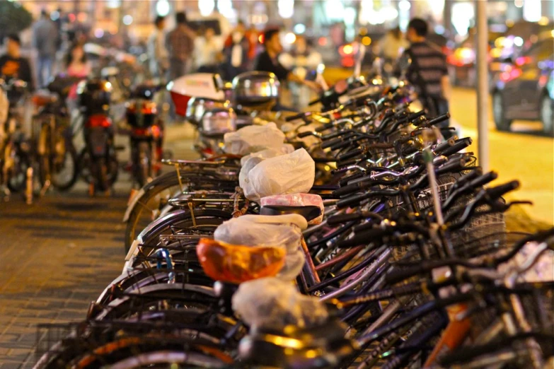 rows of bikes parked side by side on the side of a street