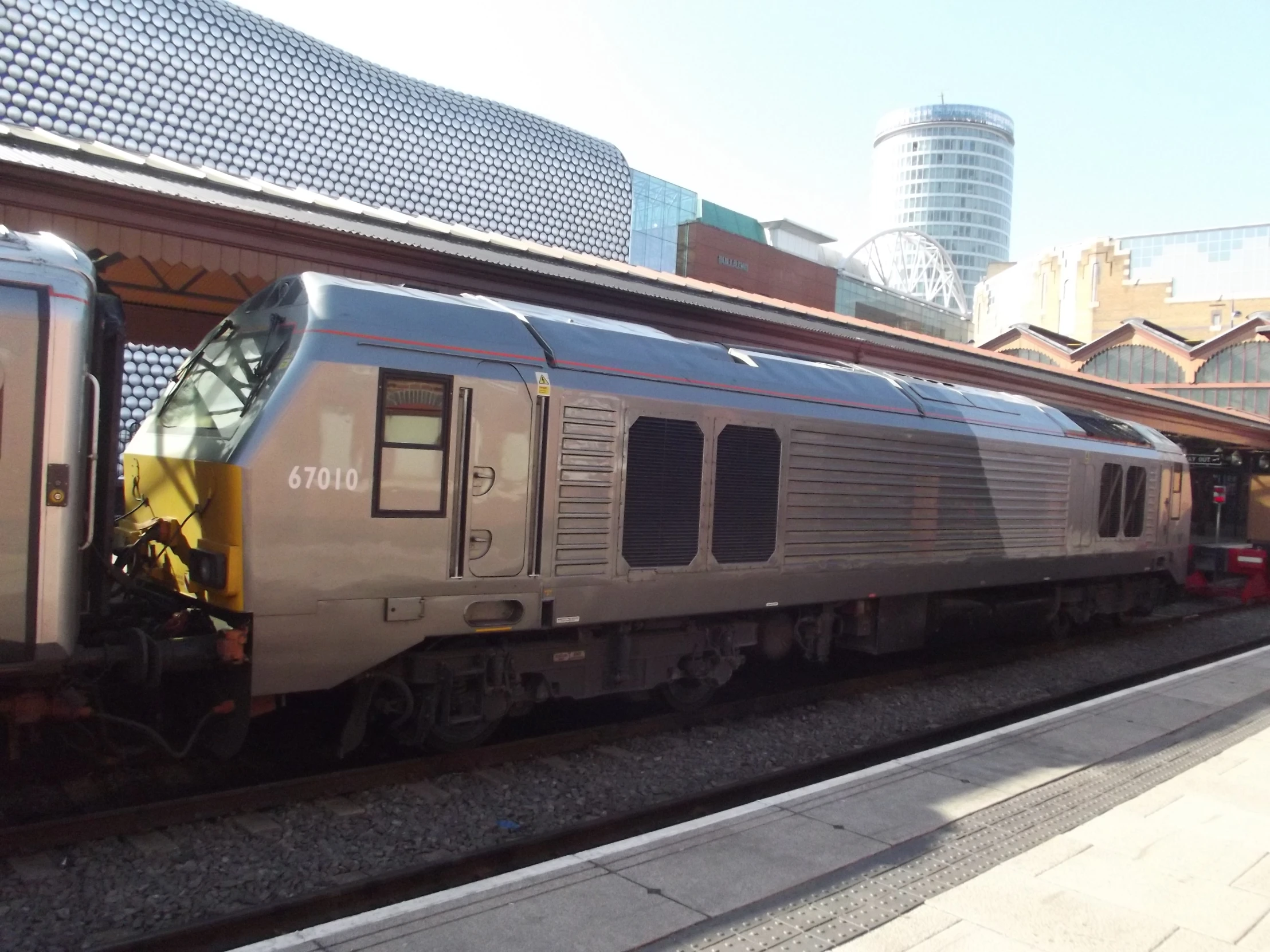 a train sitting parked at the side of the tracks in a station