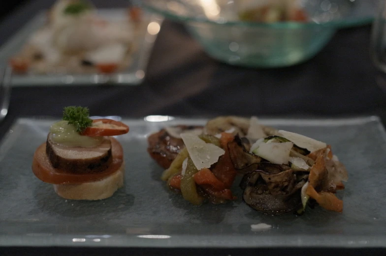 two small appetizers are sitting on a square plate