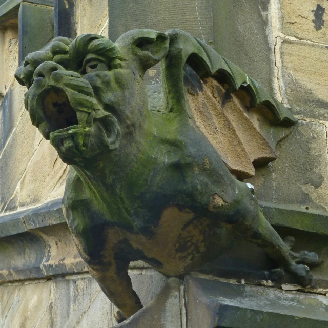 a green statue of a lion on the outside of a building