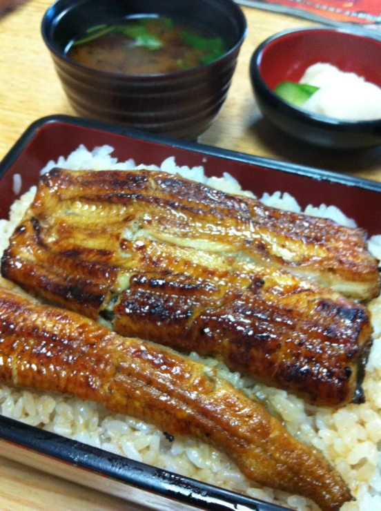 asian cuisine is served in a bowl with rice