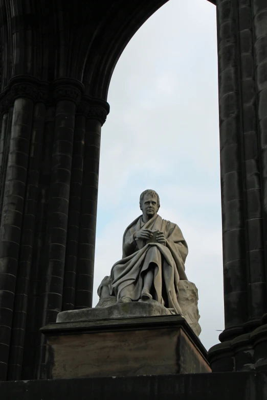 an old building with stone arches over the statue of a person