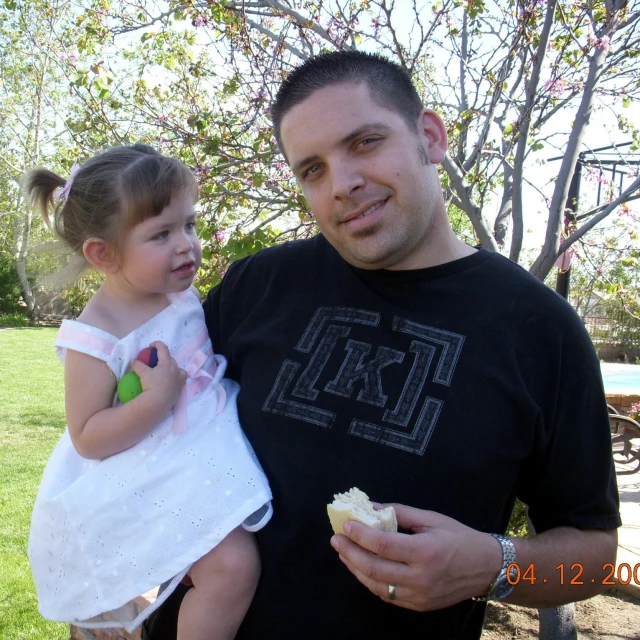 a man and a little girl are eating a cupcake