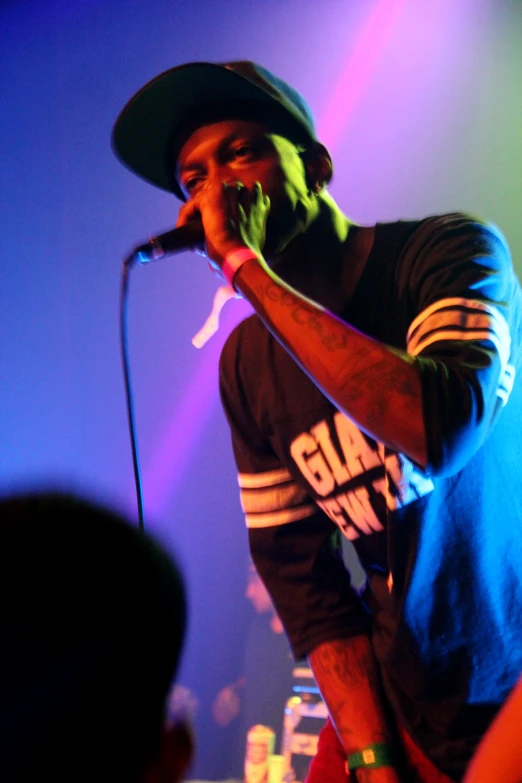 a man singing with his hands raised while standing on stage