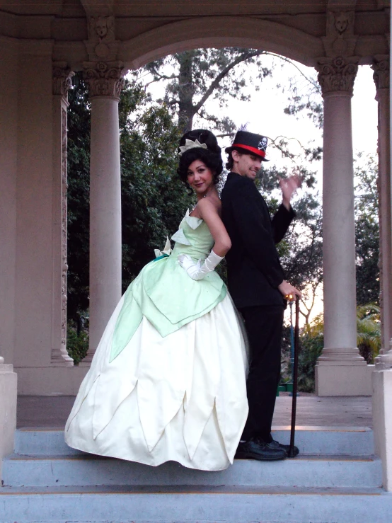 a man and a woman in dress clothes standing on some steps