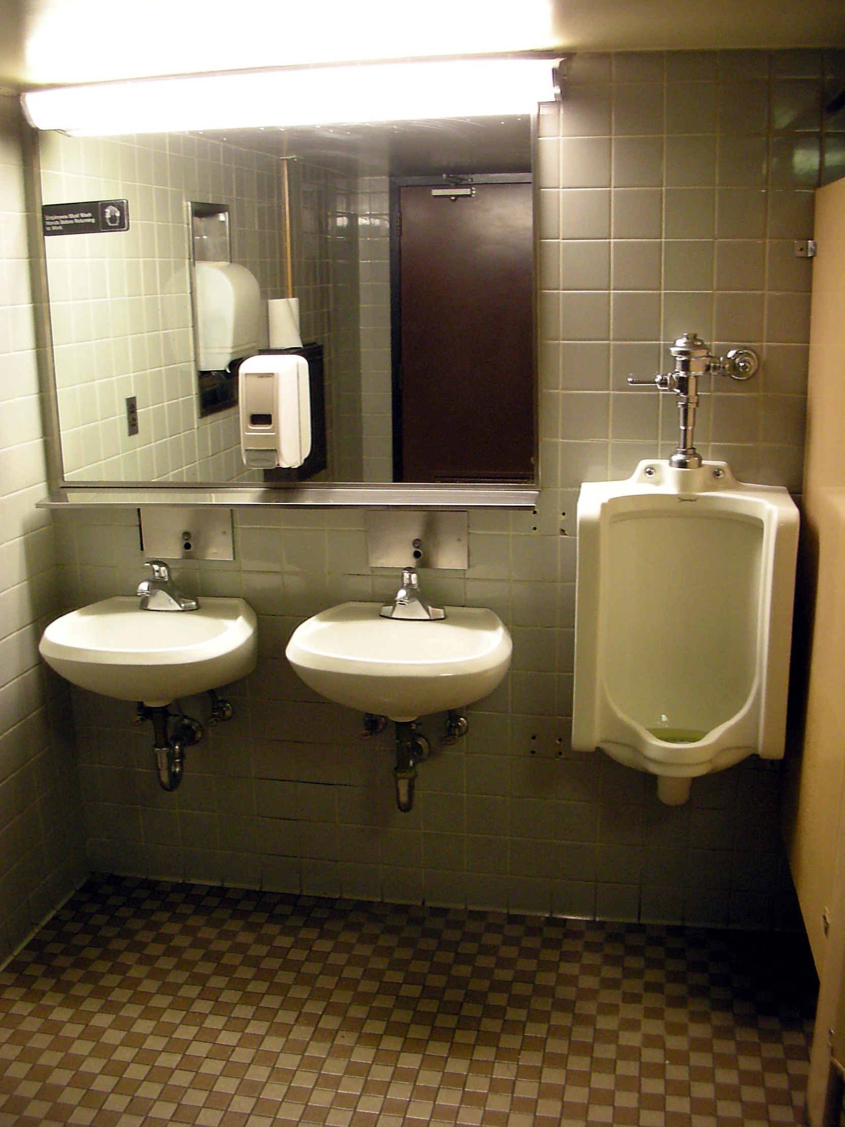 a bathroom with urinals on either side of sinks