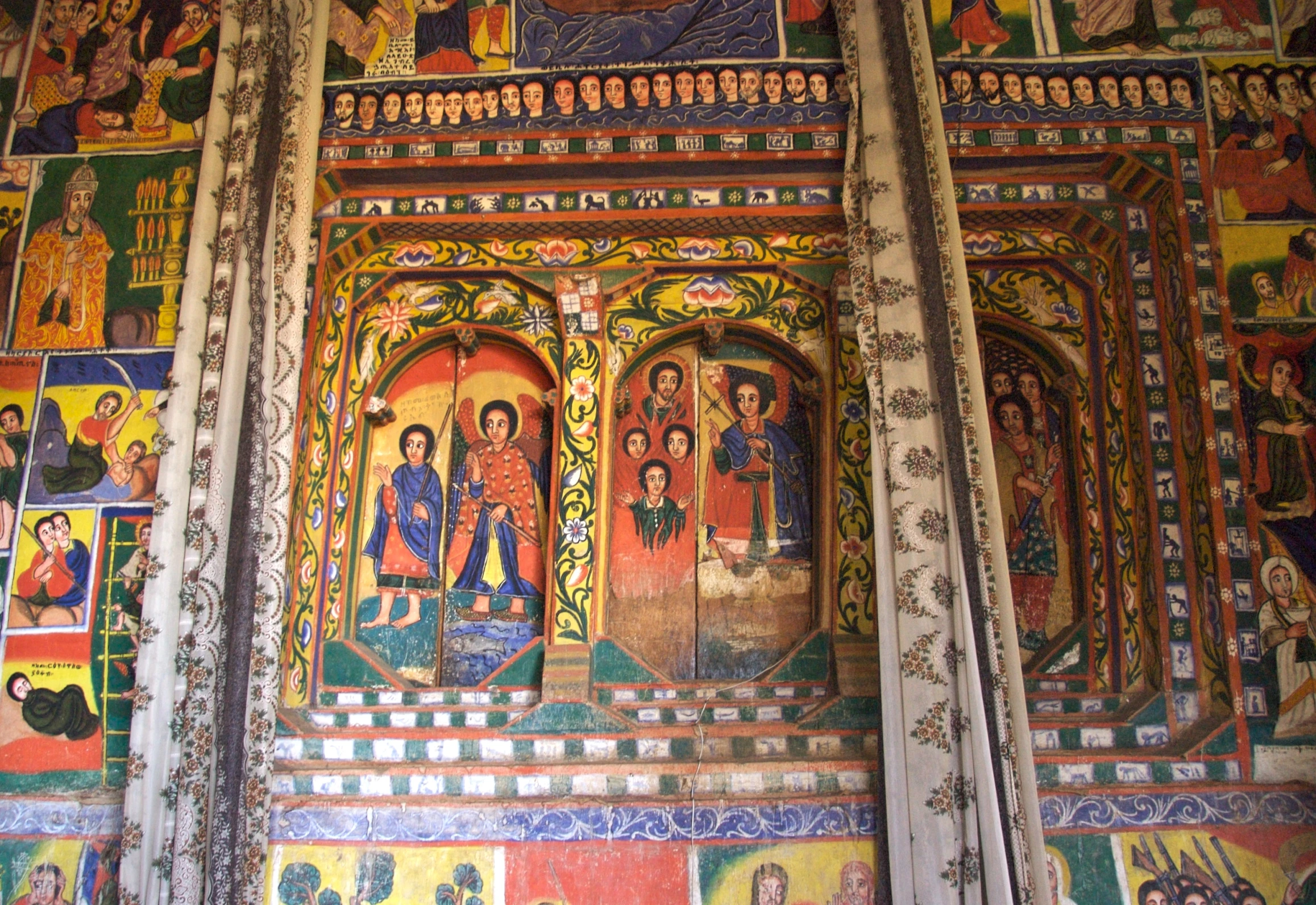 an ornate painting on a church wall, with religious icons