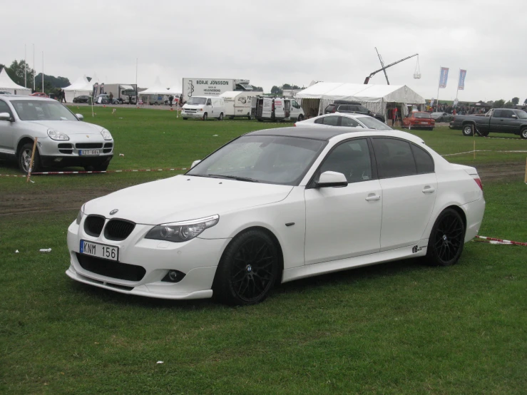 a car parked in a field near other vehicles