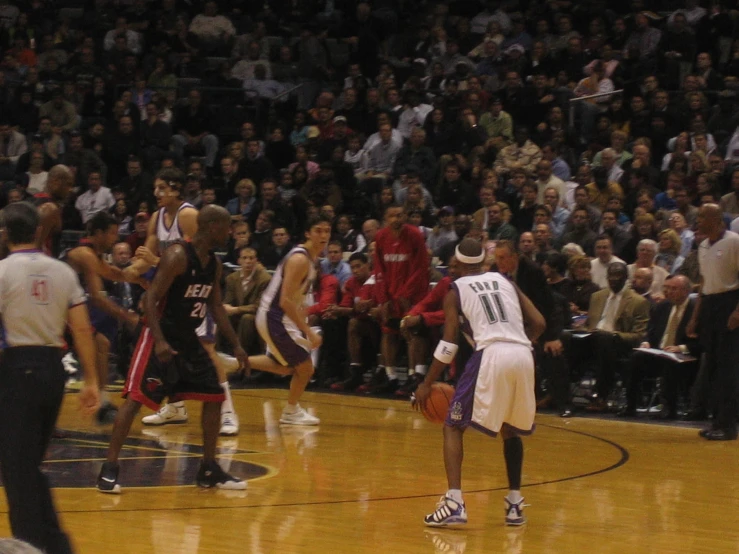 men playing basketball on a professional court with a crowd in the stands