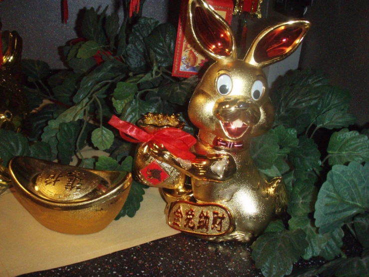 a golden rabbit statue next to some potted plants