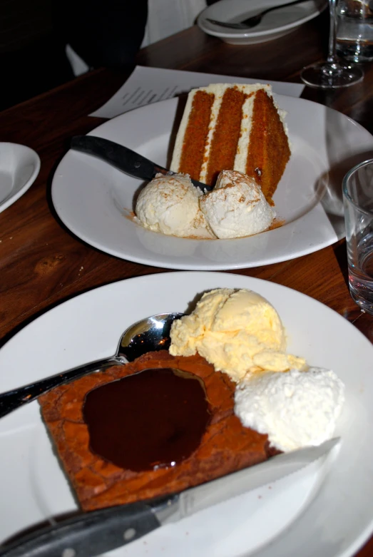 a wooden table topped with two plates filled with cake