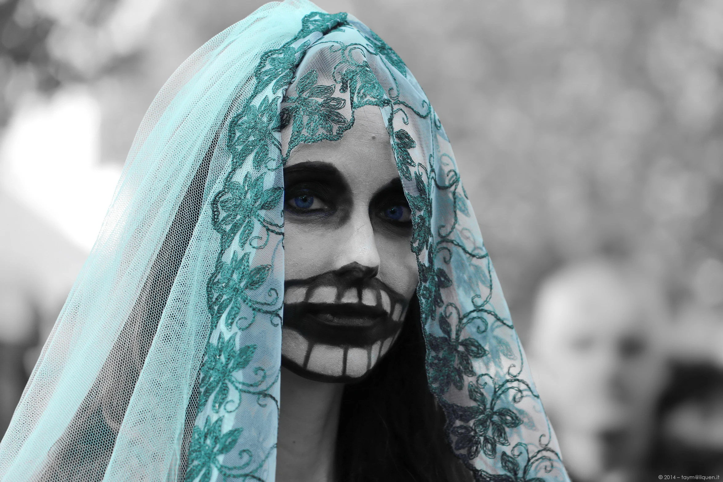 a girl in blue makeup wearing an old veil