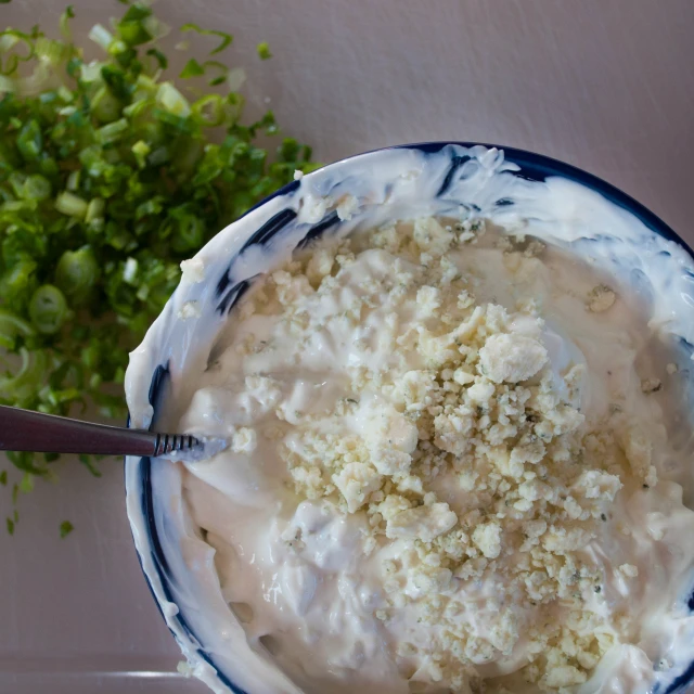 a bowl of dip surrounded by chopped celery