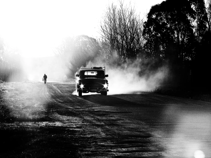 a small truck is driving down a road in the dark