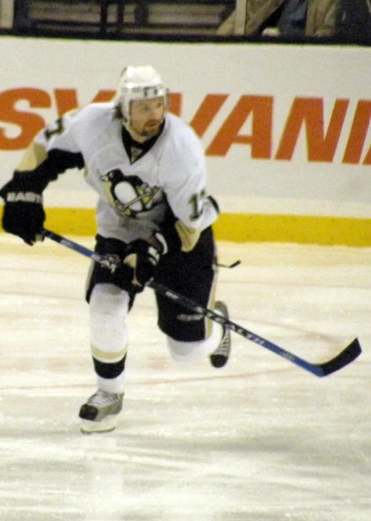 a young hockey player on the ice wearing a jersey and skates