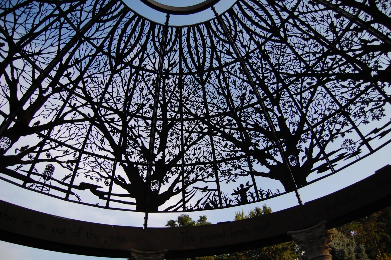 a circular building has a clock and tree nches