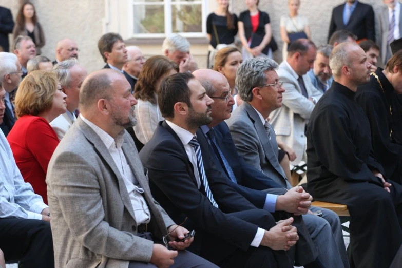 several people are sitting side by side in front of an audience