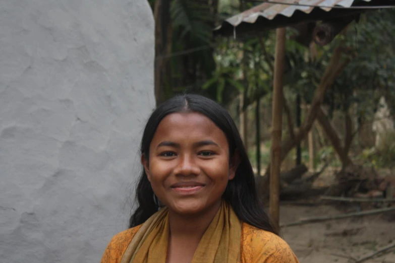 the young woman is smiling in a yellow shirt