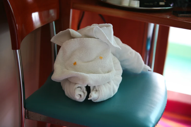 a white towel folded on top of a blue chair