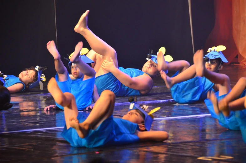 a group of people in blue dresses sitting on the floor