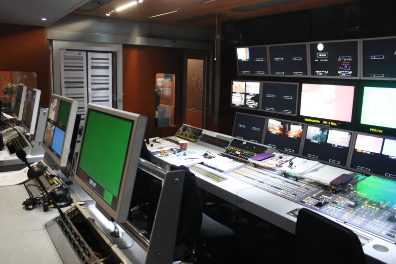 a control room has multiple monitors and other equipment