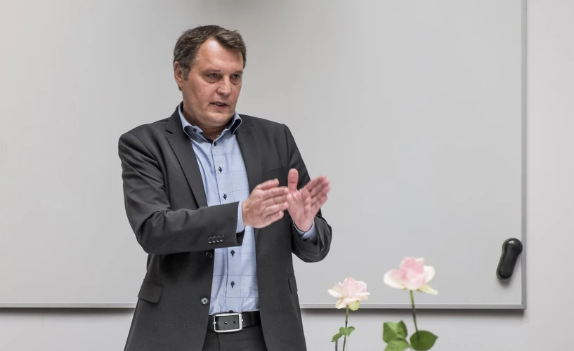 a man talking in front of a projector screen