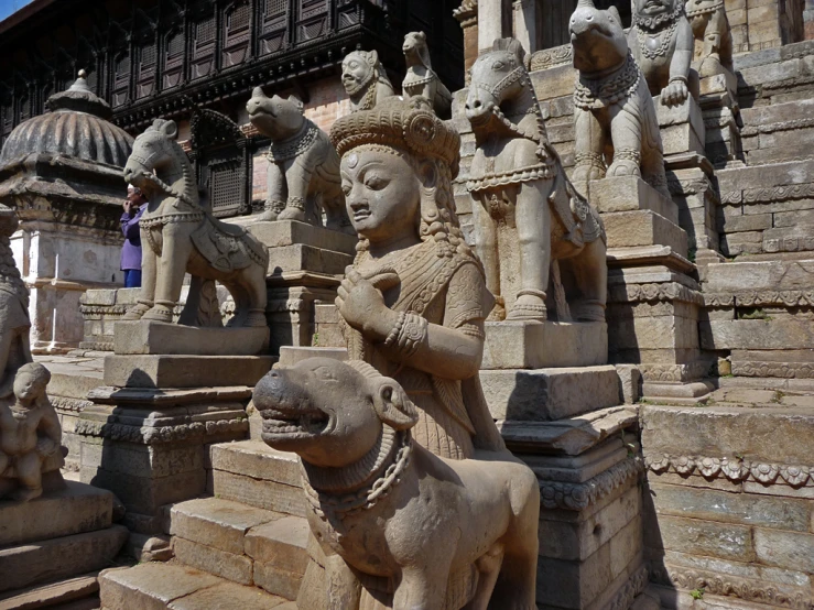 carved marble sculptures of women and dogs near a building