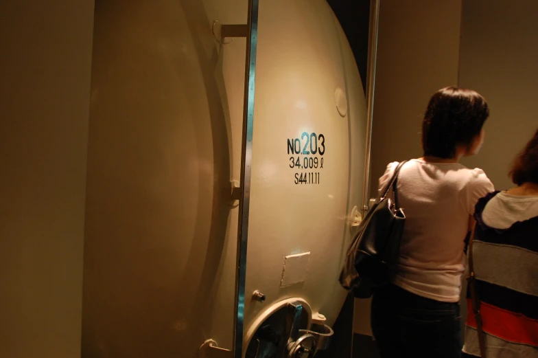 two people looking at an old surfboard in a museum