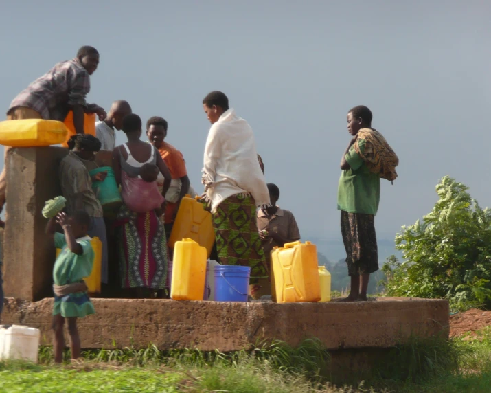 several people gathered around some plastic containers and bags