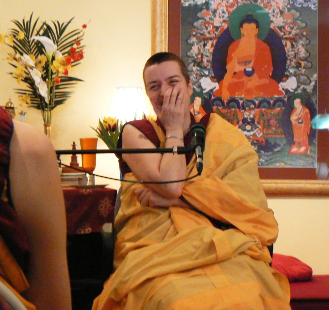 a man wearing a robe with his eyes closed sitting in a chair
